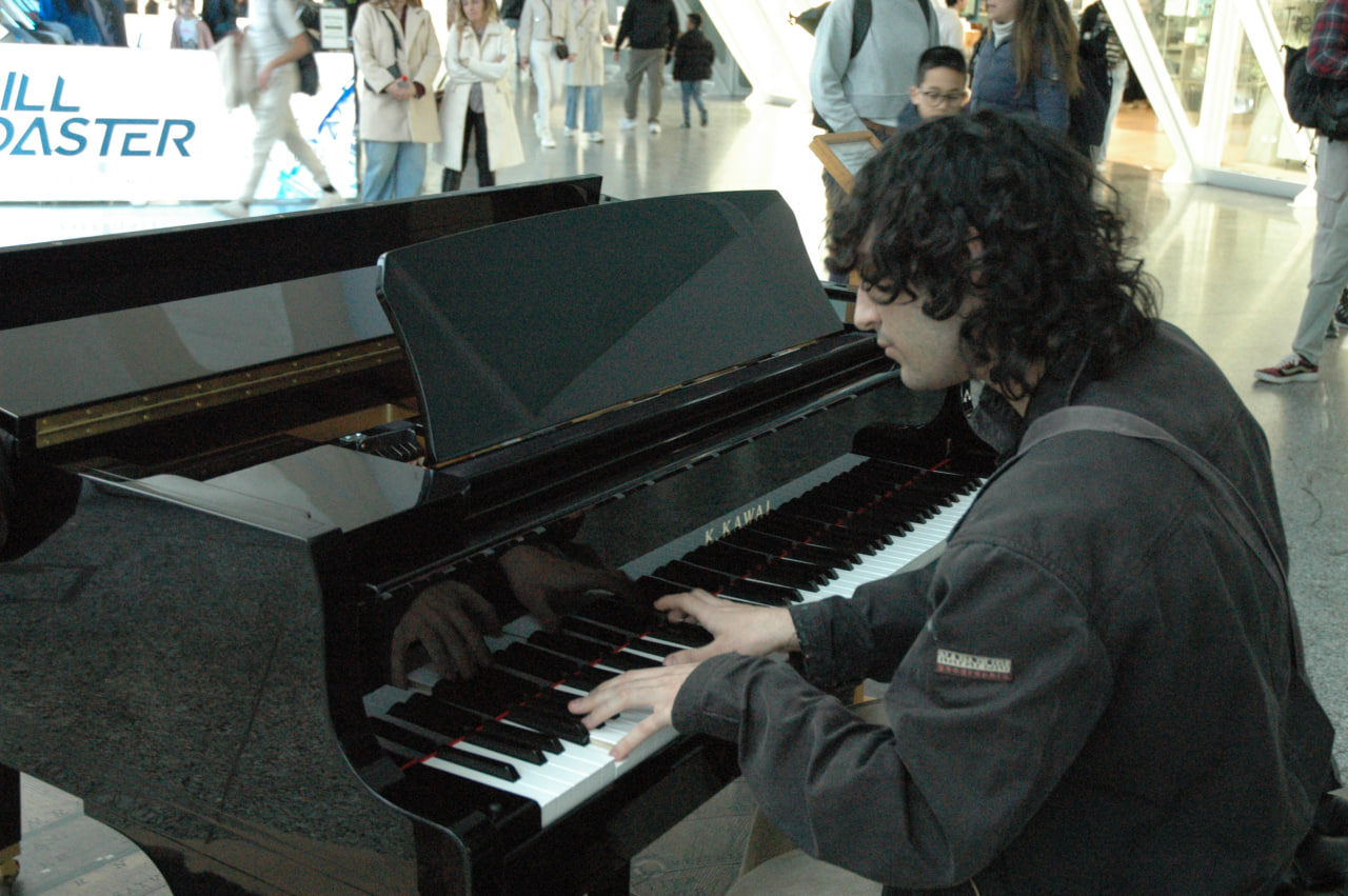 Teo Torres playing piano in a public space